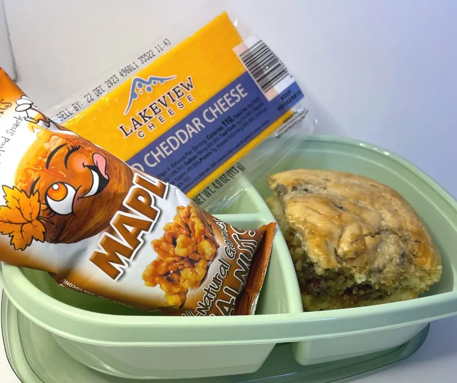 serving of pB&J Pancake tray bake, maple walnuts package, and cheddar cheese package in container