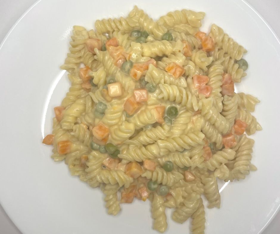rotini macaroni and cheese with carrots and some green peas on white plate