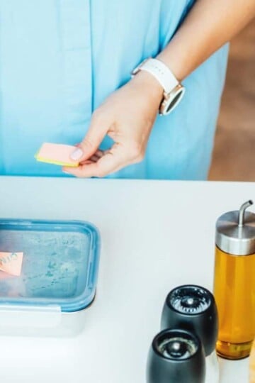 woman in blue shirt filling lunch container with dollar tree lunchables