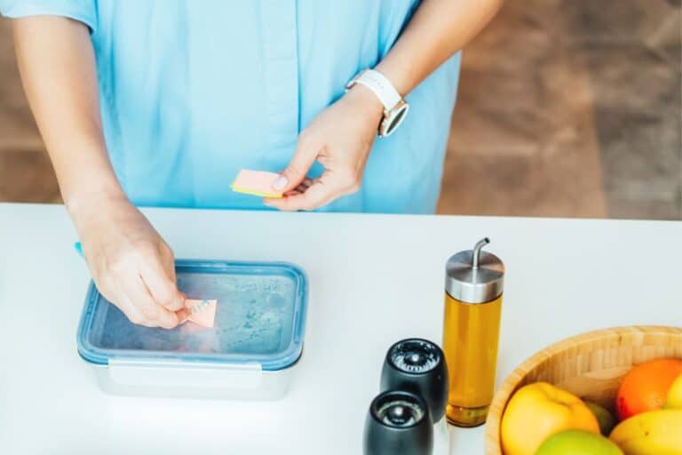 woman in blue shirt filling lunch container with dollar tree lunchables