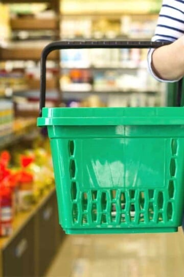 woman in striped shirt with green basket in Dollar Tree
