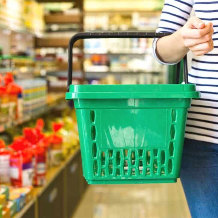 woman in striped shirt with green basket in Dollar Tree