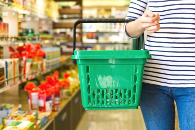 woman in striped shirt with green basket in Dollar Tree