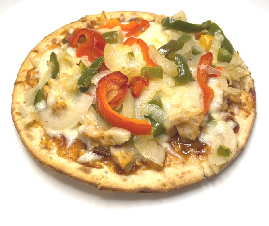personal mini chicken bbq pizza with green and red peppers and onions and mozzarella cheese onw hite plate