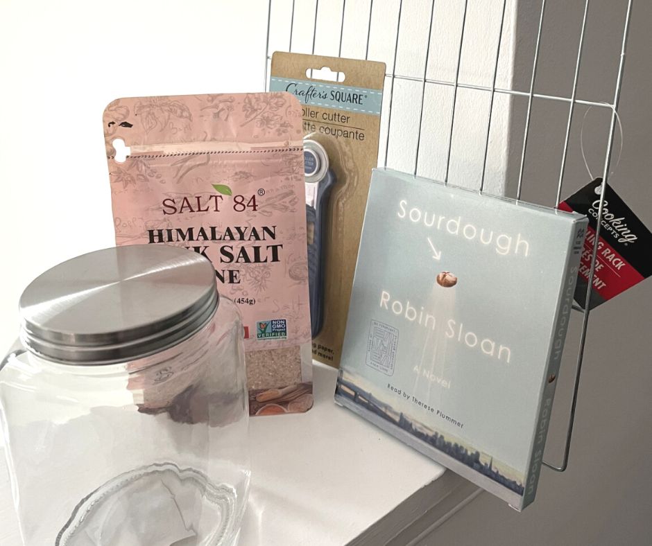 cooling rack, roller cutter, Sourdough audiobook, himalayan sea salt, and mason jar, white background