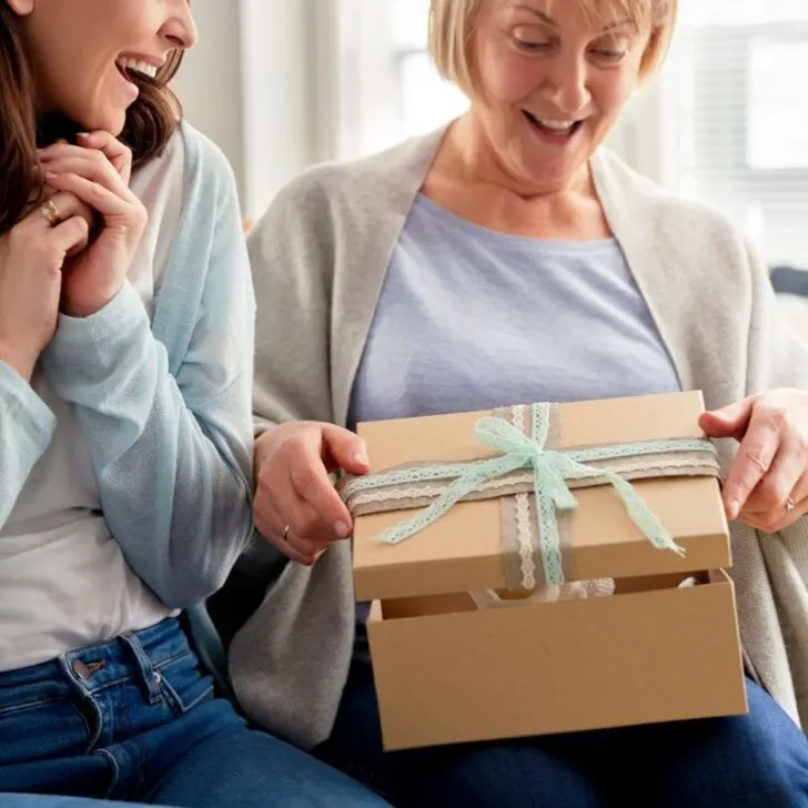 adult daughter handing Mom gift from Dollar Tree