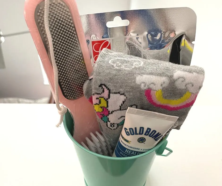 fun socks, foot mask, healing cream, etc. in a teal tin bucket