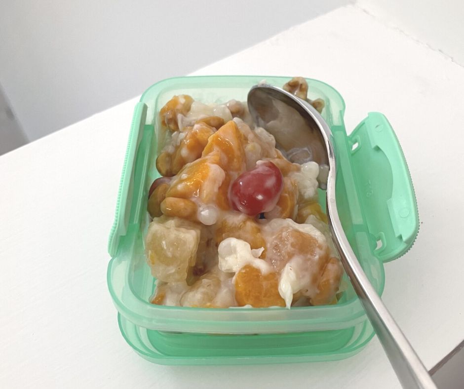 light green Dollar Tree snack container with nutty Bahama fruit salad on white background