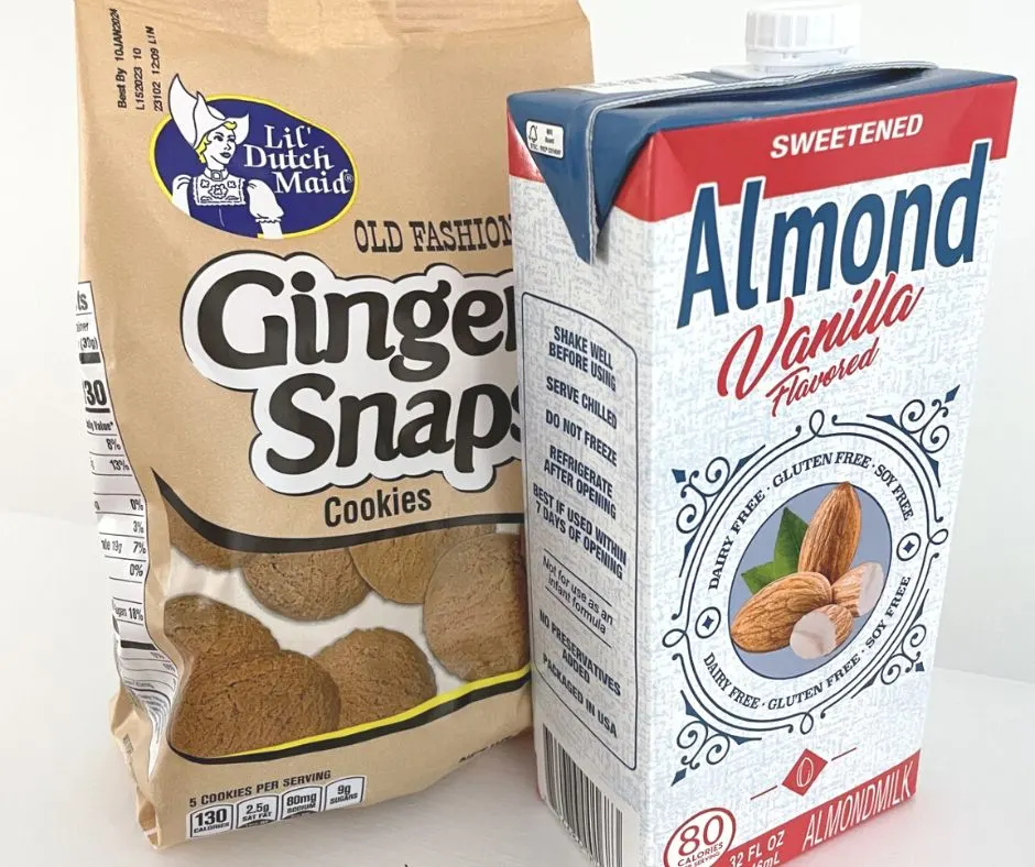 tan ginger snaps cookies next to sweetened almond vanilla milk on white background