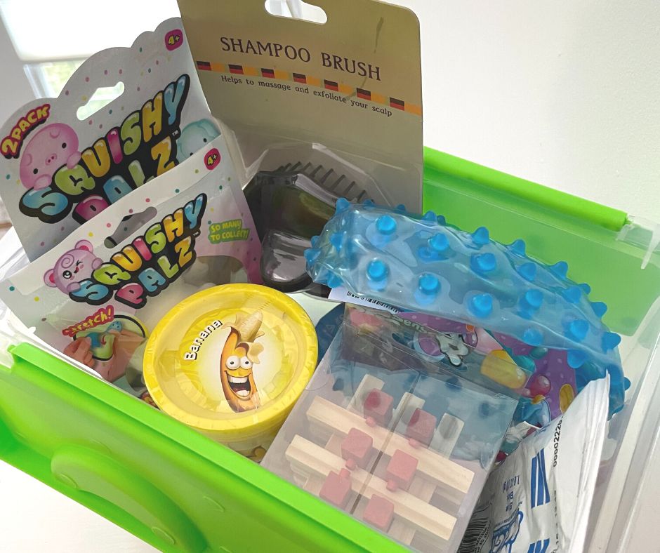 plastic container with neon green lid filled with sensory toys like puzzle, squishy palz, shampoo brush, etc.