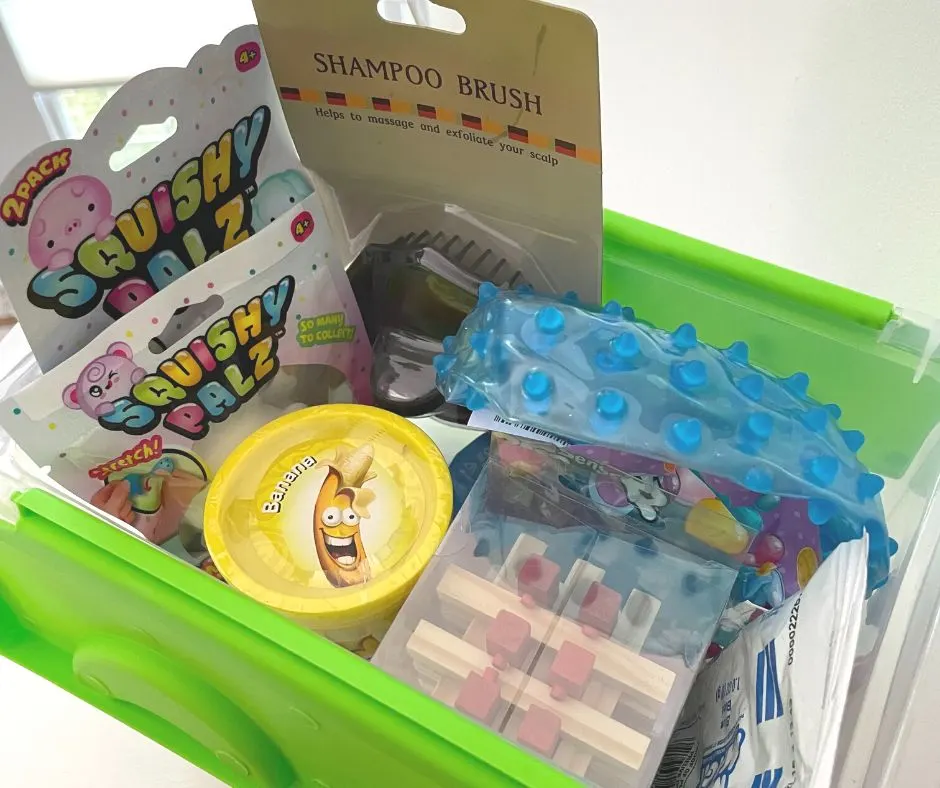 plastic container with neon green lid filled with sensory toys like puzzle, squishy palz, shampoo brush, etc.