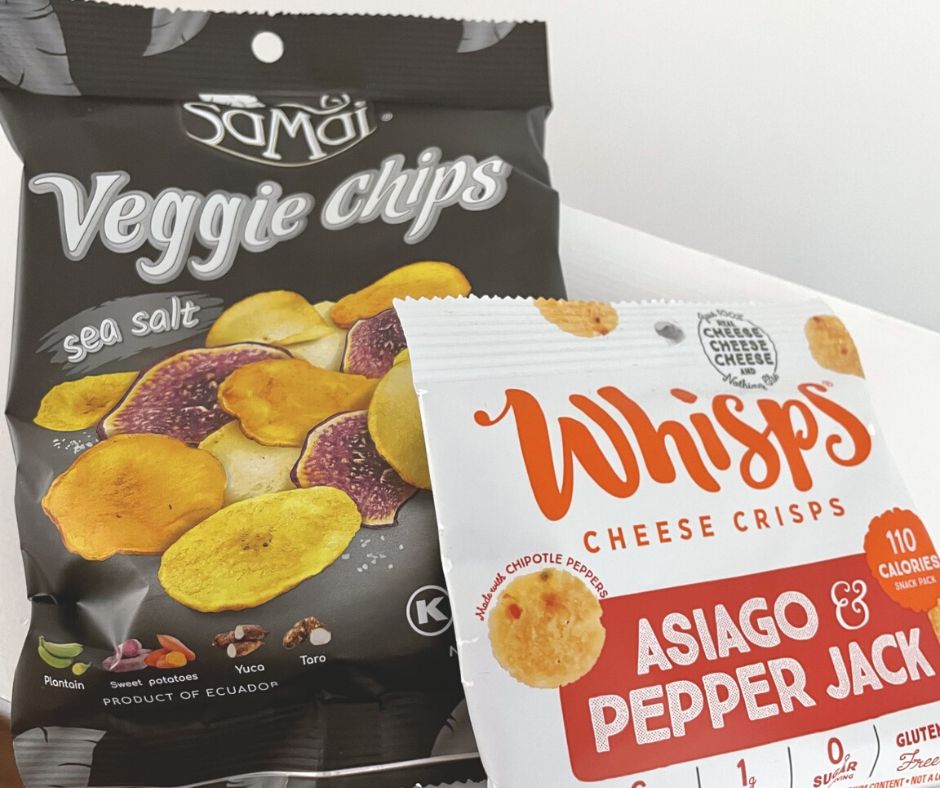 black veggie chips bag next to Asiago & Pepper Jack bag on desk