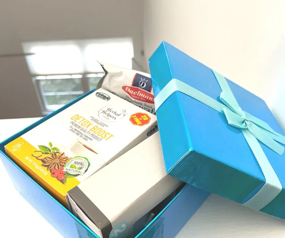 bright blue gift box filled with detox teas, stroopwafels, floating candles, etc.