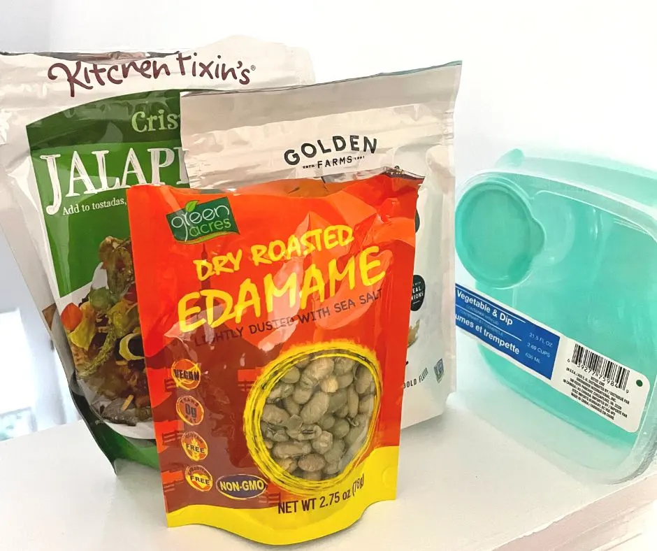 salad container, next to packages of crispy jalapenos, edamame, and crispy onions