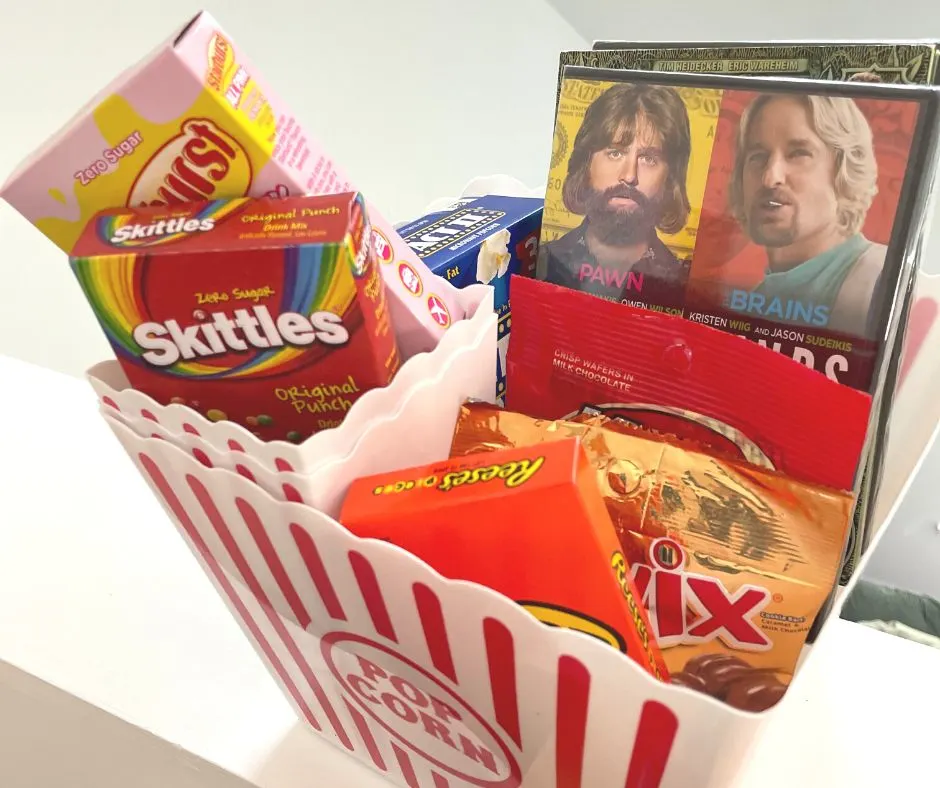 big popcorn bucket with movies, popcorn, drink flavors, and candy