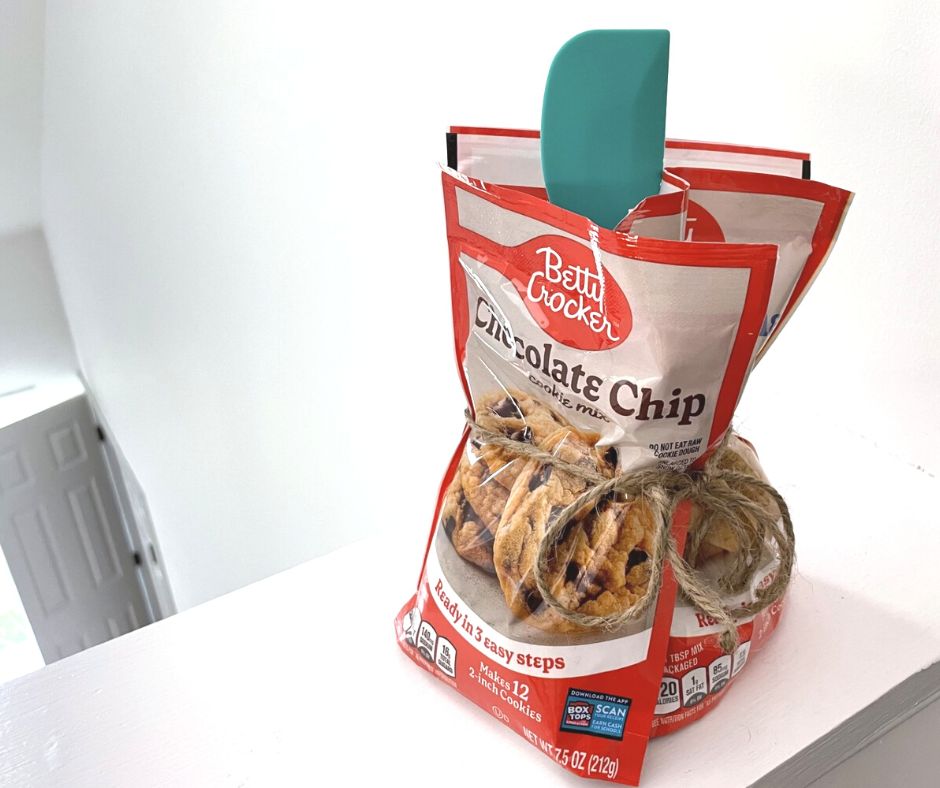 three packages of Betty Crocker cookies with teal spatula in center, tied in jute twine