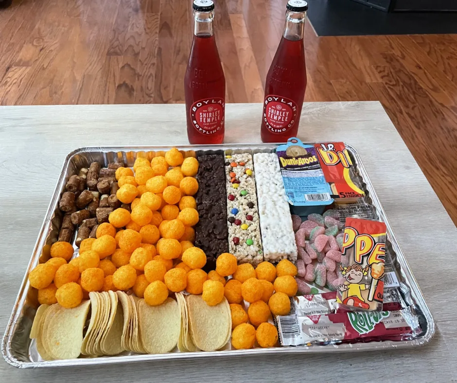 snack and junk food filled charcuterie board with 80s/90s snacks on table