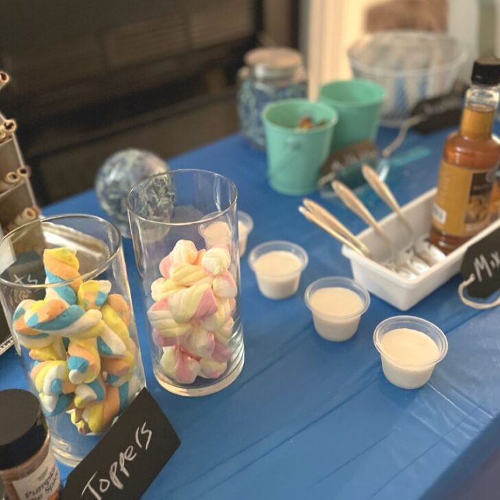 hot chocolate bar with lots of toppings and containers on blue tablecloth