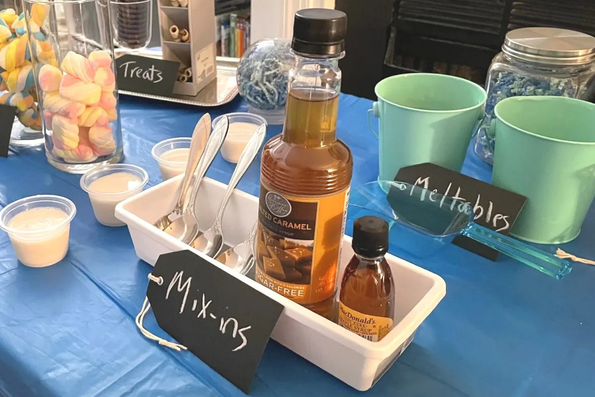 caramel syrup and maple syrup in a container, with "mix-ins" sign in front