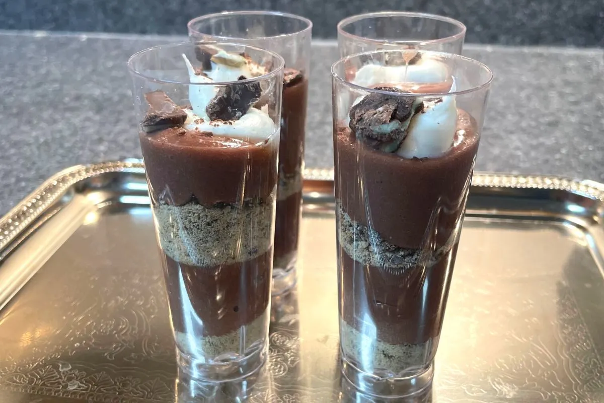 four dessert shooters on silver tray