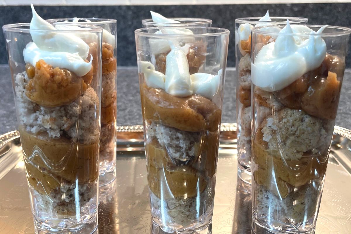 six dessert shooters on silver tray with Peanut butter, banana muffin, and vanilla icing