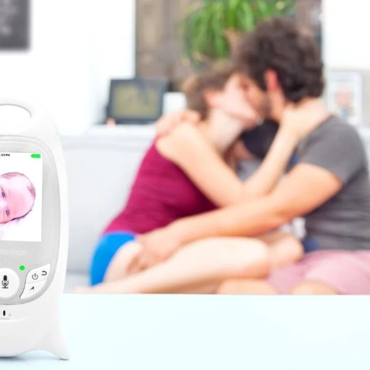 couple kissing in background with baby monitor in front