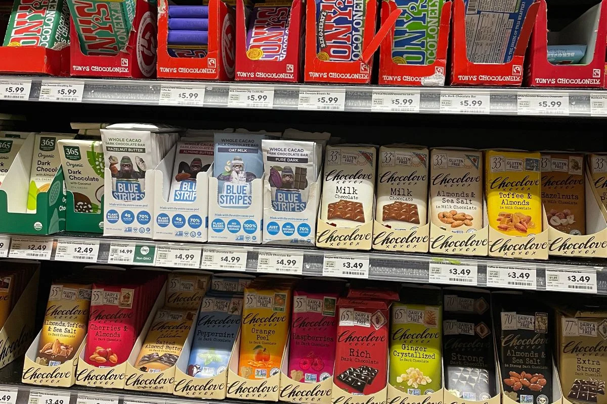 three shelves full of gourmet chocolate bars in store