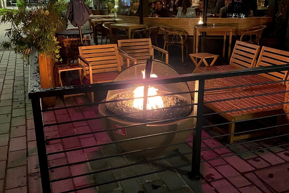 restaurant with outdoor patio, wooden chairs, and fire pit