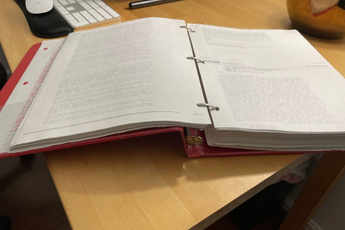 red binder opened with tons of emails in it, blurred for the image