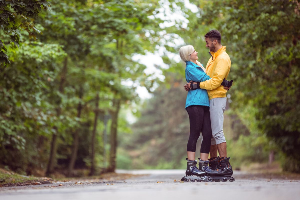 couple hugging each other, smiling, with rollerblades in the park