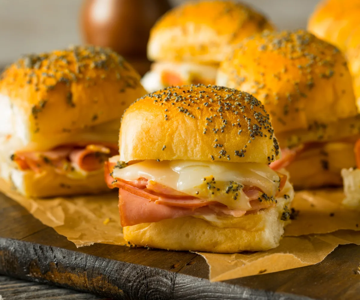 hot slider sandwiches in Hawaiian rolls on dark cutting board