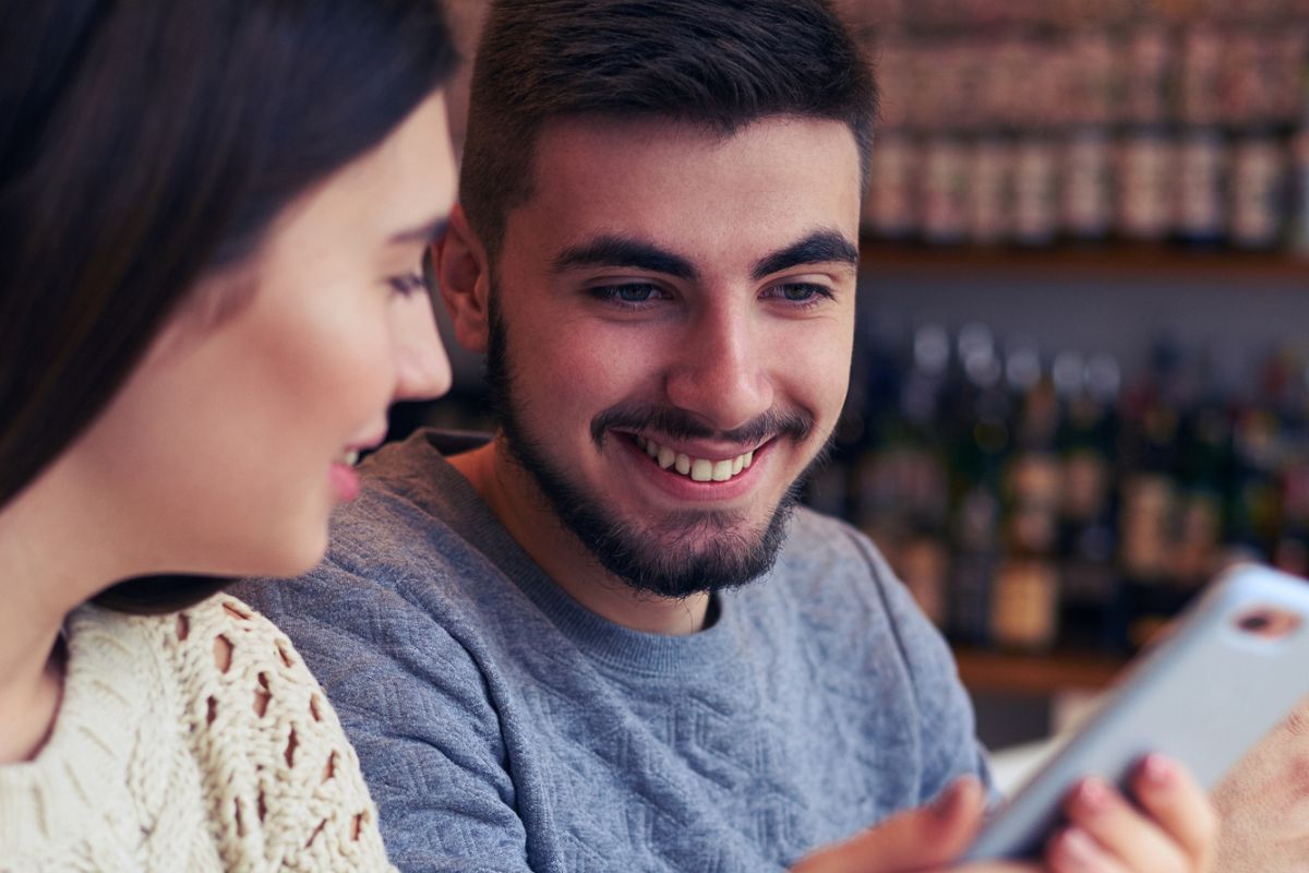 couple on coffee shop date listening to crime podcast together