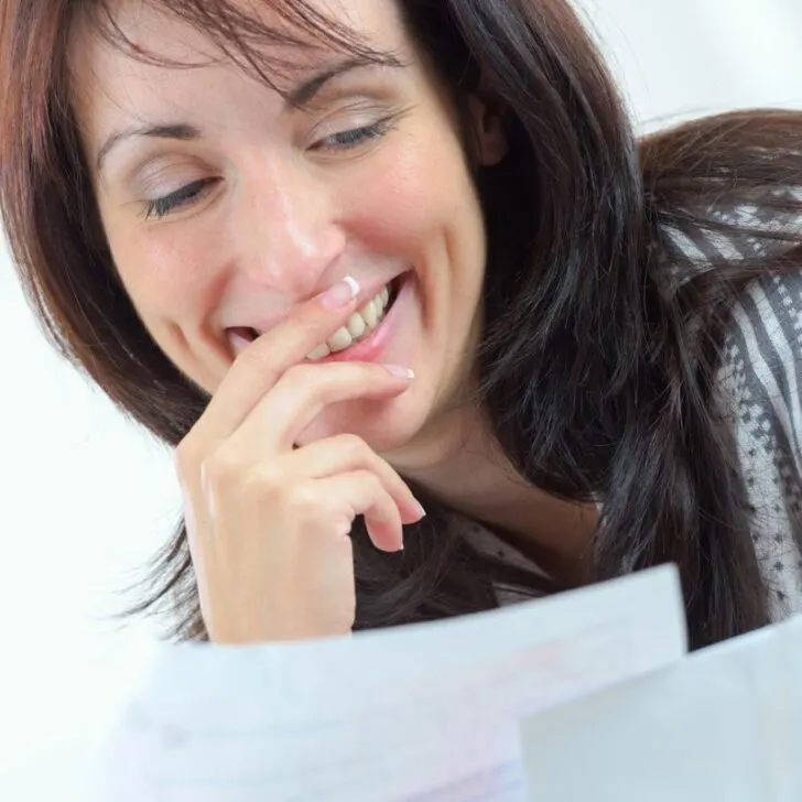 woman looking at receipts and budget smiling pleasantly