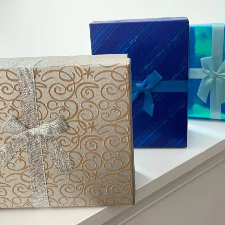 three Dollar Tree gift boxes that are silver, light blue, and royal blue, on white background