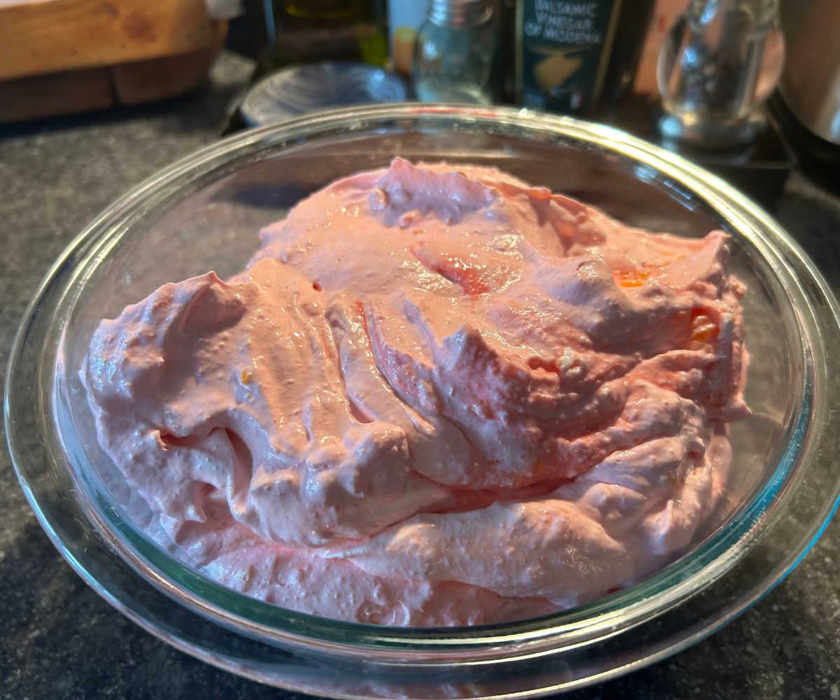 light pink fruit dessert salad in glass bowl