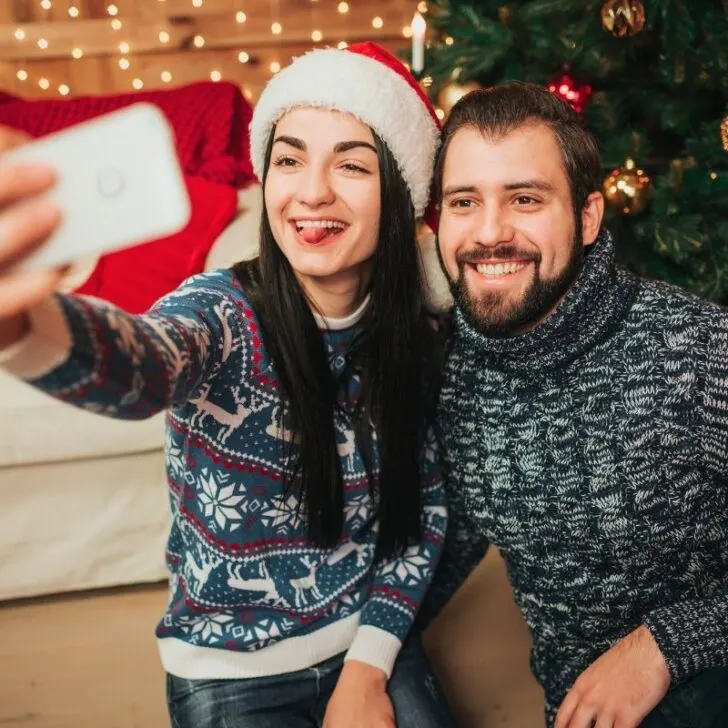 couple wearing santa hats and taking funny selfie together