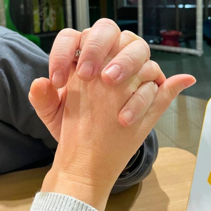 married couple holding hands with wedding rings on