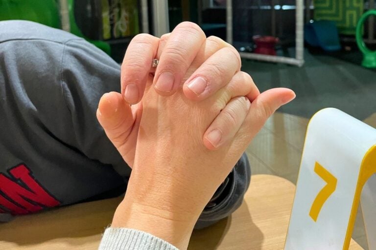 married couple holding hands with wedding rings on