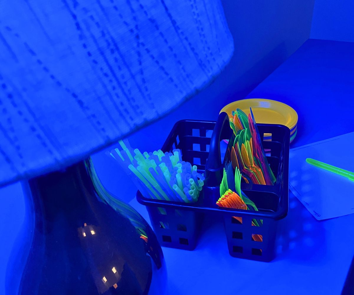 black light on and fluorescent utensils, plates, etc. on table