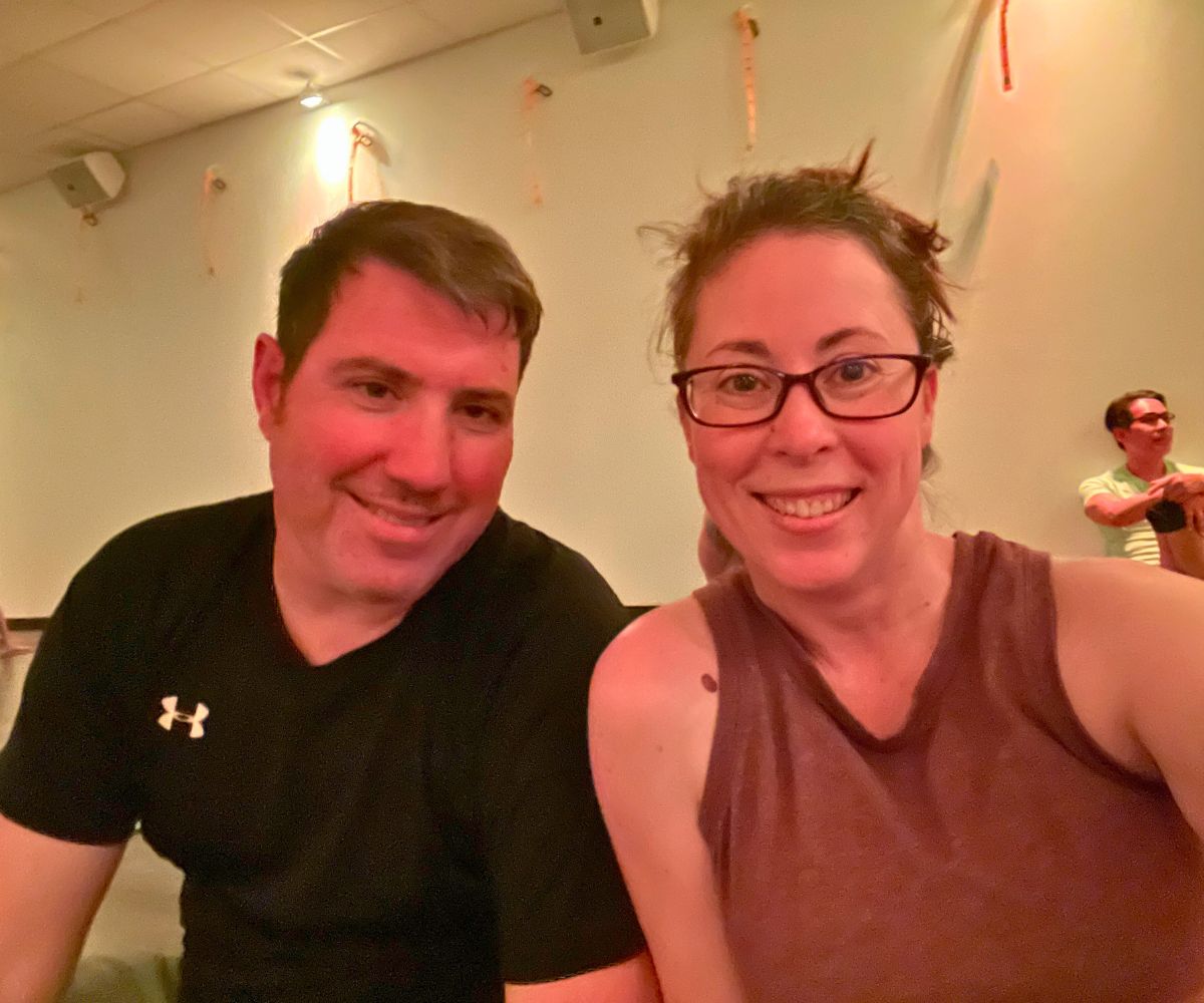 sweaty couple smiling in hot yoga studio room