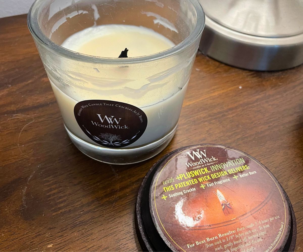 WoodWick candle opened on bedside table, half used up