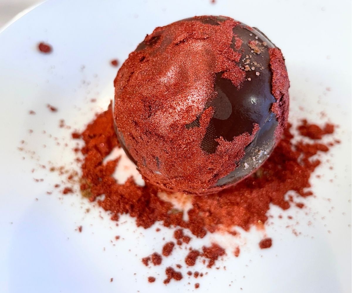 hot cocoa bombshell partially dipped in red glitter on plate