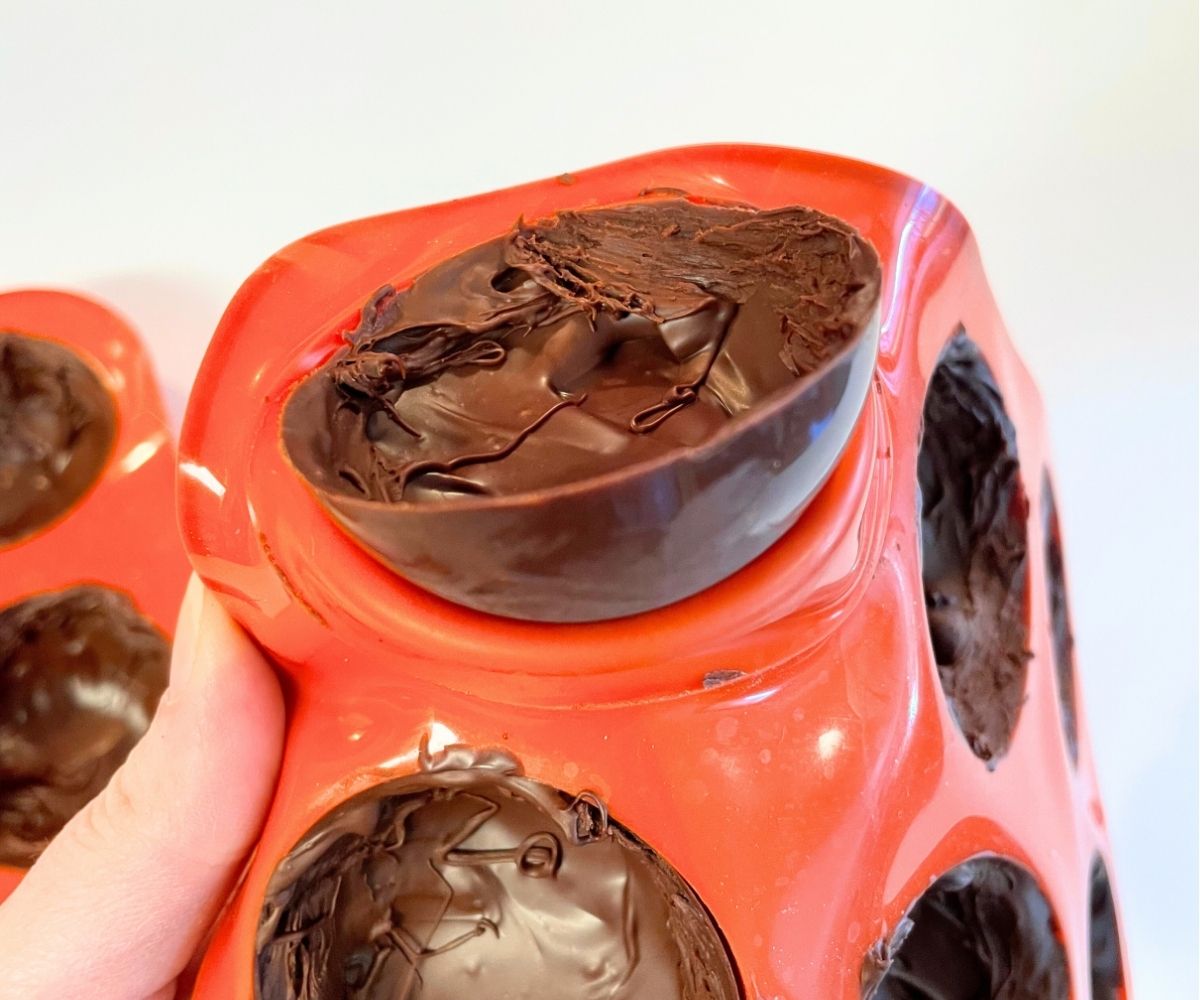 woman popping hot cocoa bombshell out of mold