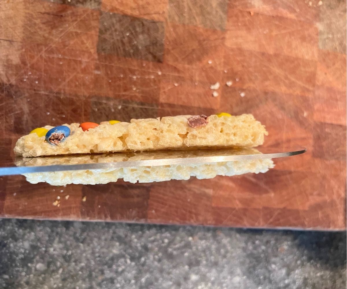 Woman slicing Rice Krispies Treat in half lengthwise