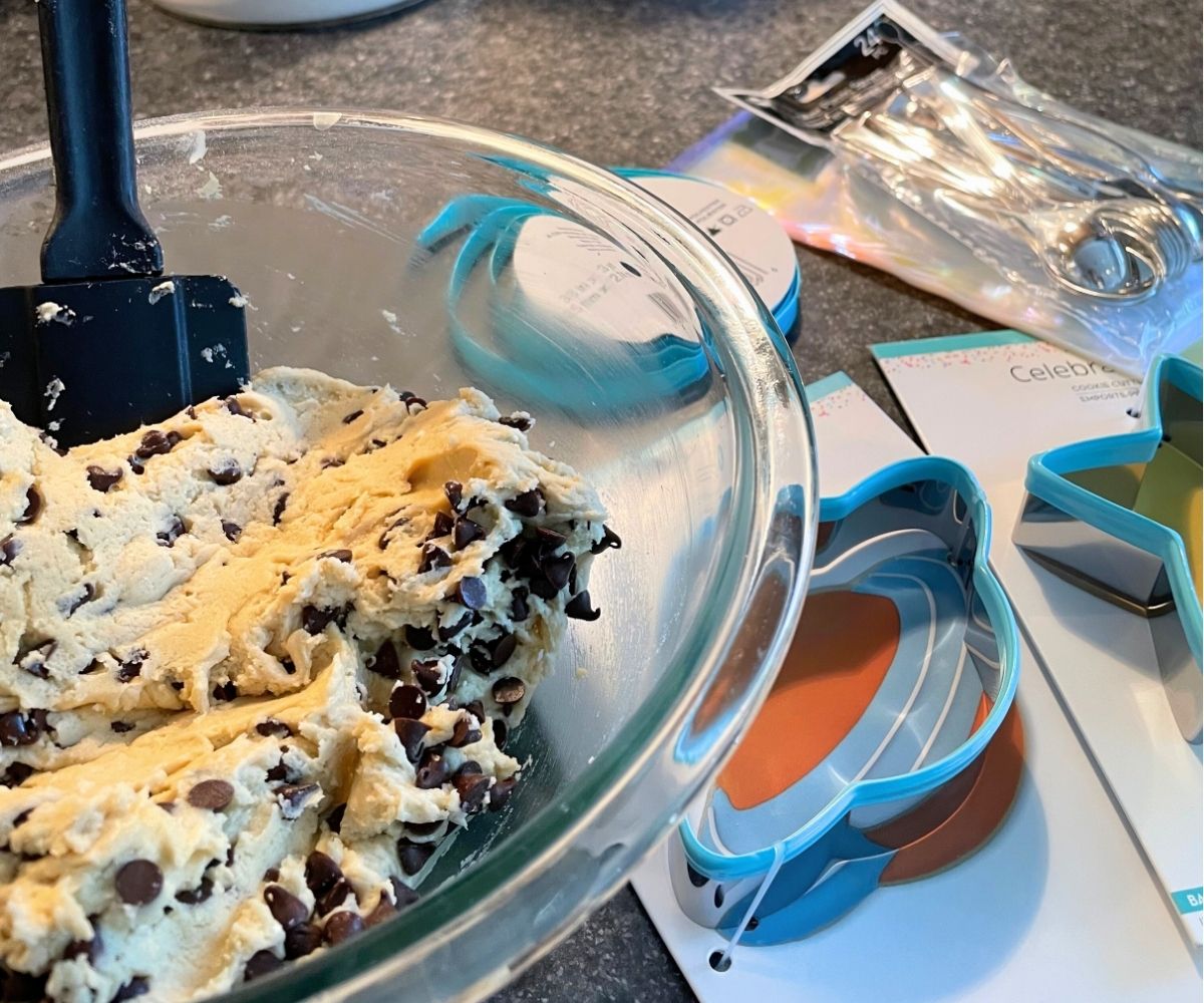 outer space cookie dough cutters next to bowl full of safe cookie dough to eat