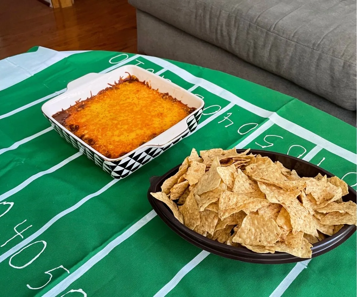 homemade field football tablecloth with hot dip and football-shaped bowl of chips on top