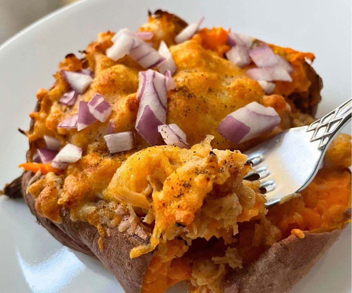 fork taking a bite out of the stuffed BBQ chicken sweet potato