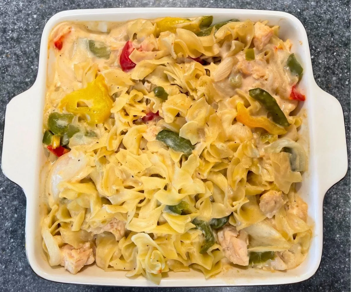 8" X 8" casserole dish filled with noodles, bell peppers, and chicken in a sauce