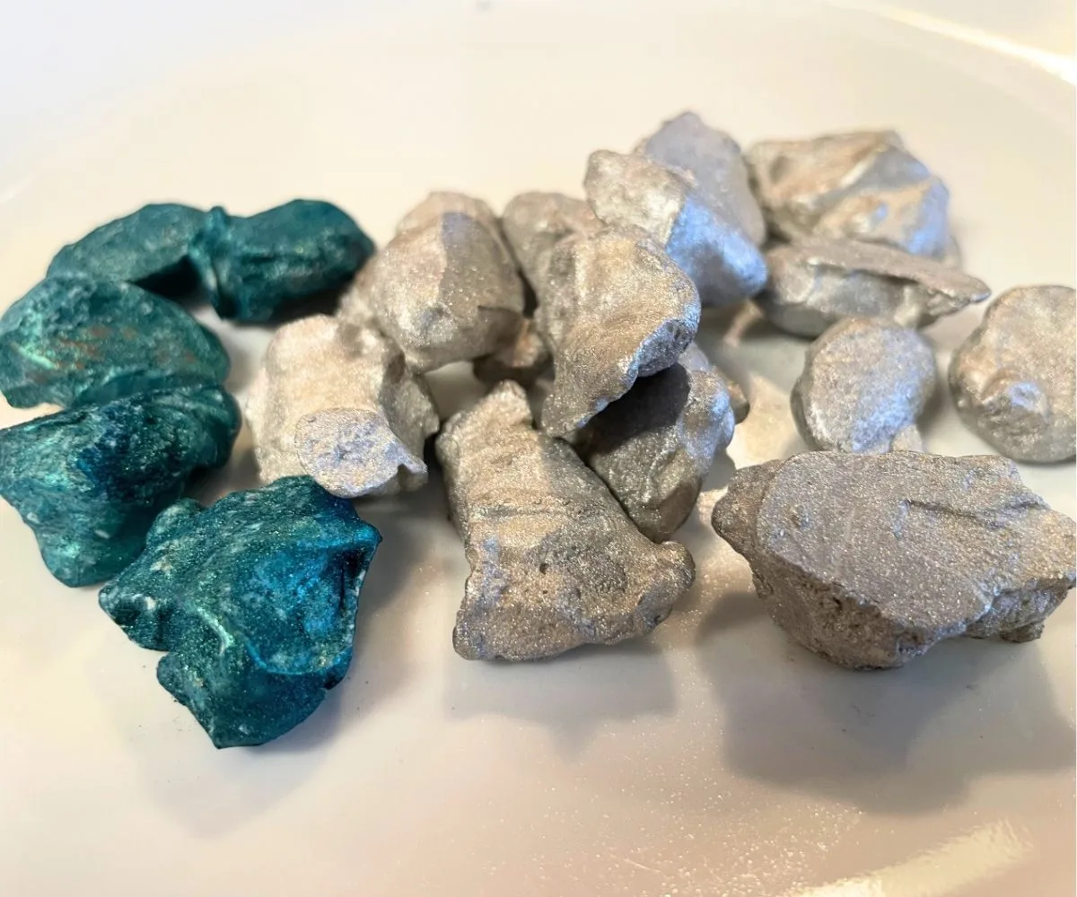 white plate filled with glittery edible gemstones, teal and silver