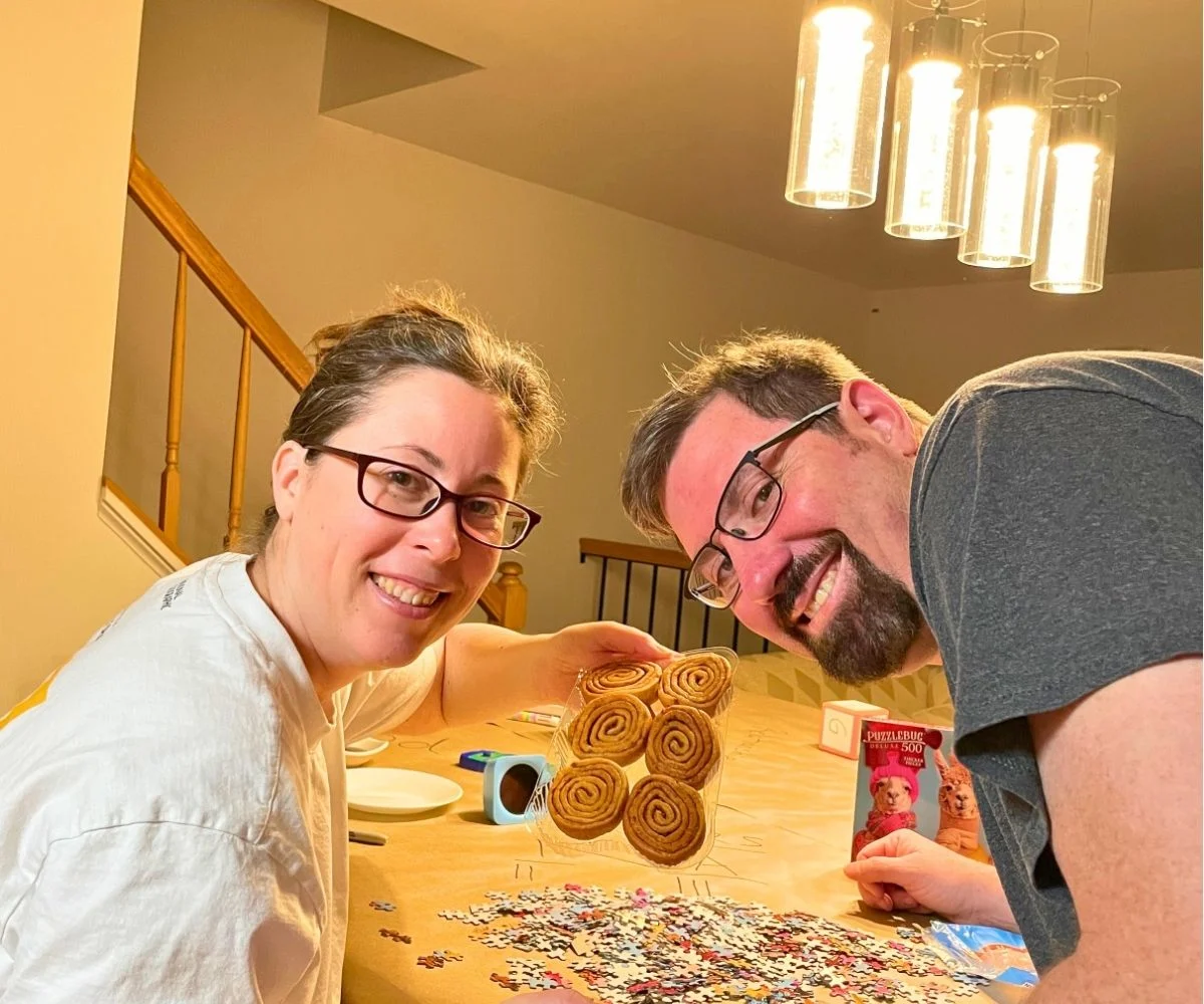 author and husband smiling to camera, holding up Pecan Twirls